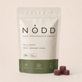 A stand-up pouch of NODD Golf Performance Chews in Wild Berry flavor, shown on a light beige background with three berry-shaped chews placed in front.