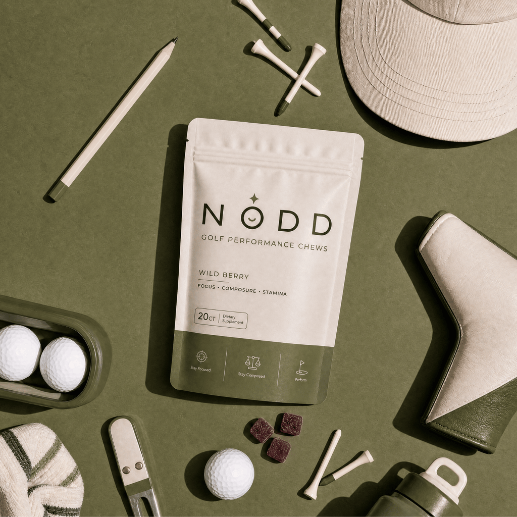 A stand-up pouch of NODD Golf Performance Chews in Wild Berry flavor, styled in a flat-lay with golf-themed props on an olive green background.